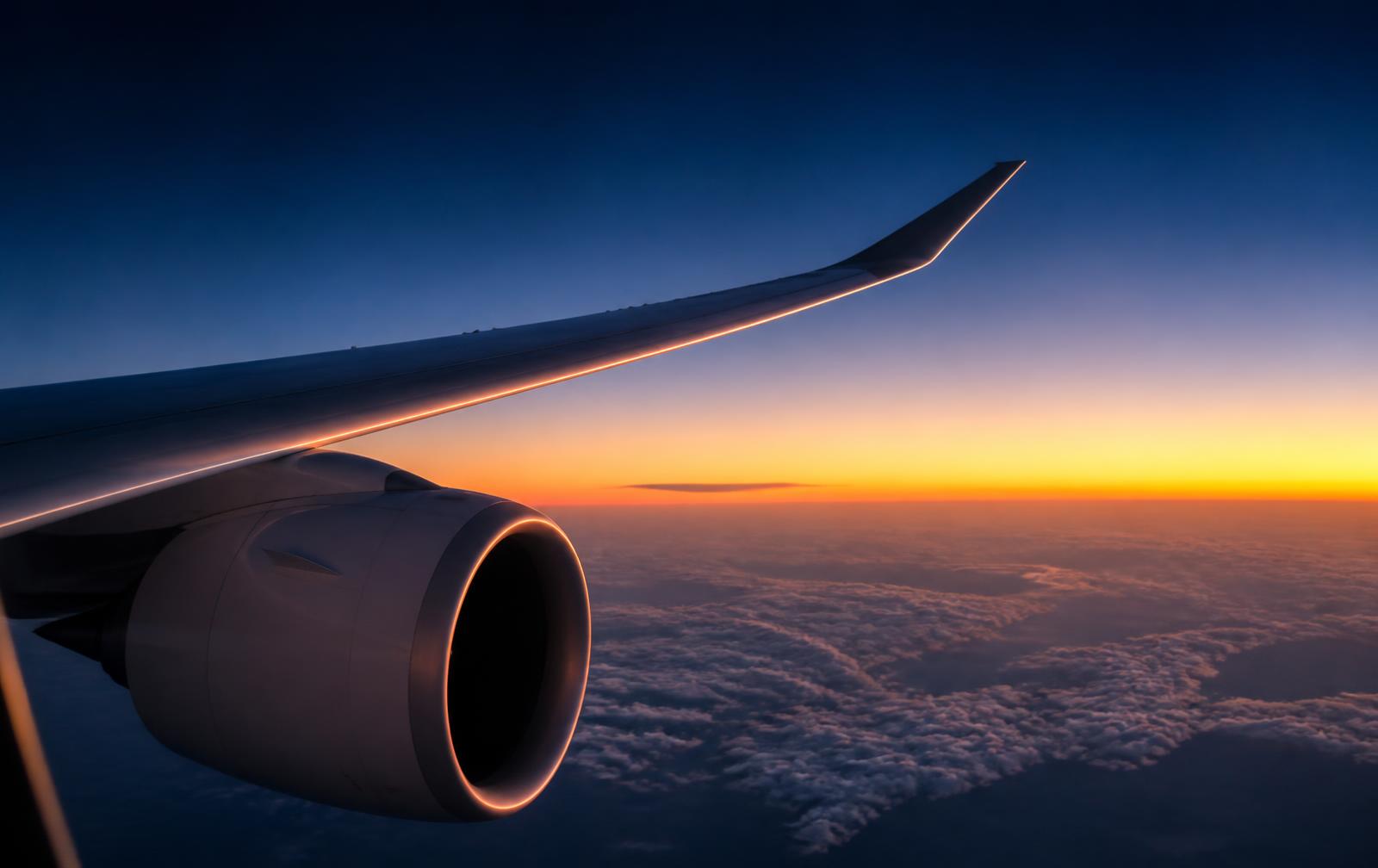Aircraft wing and engine at dusk